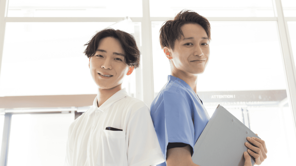 背中合わせに立つスクラブと白衣を着た男性スタッフ