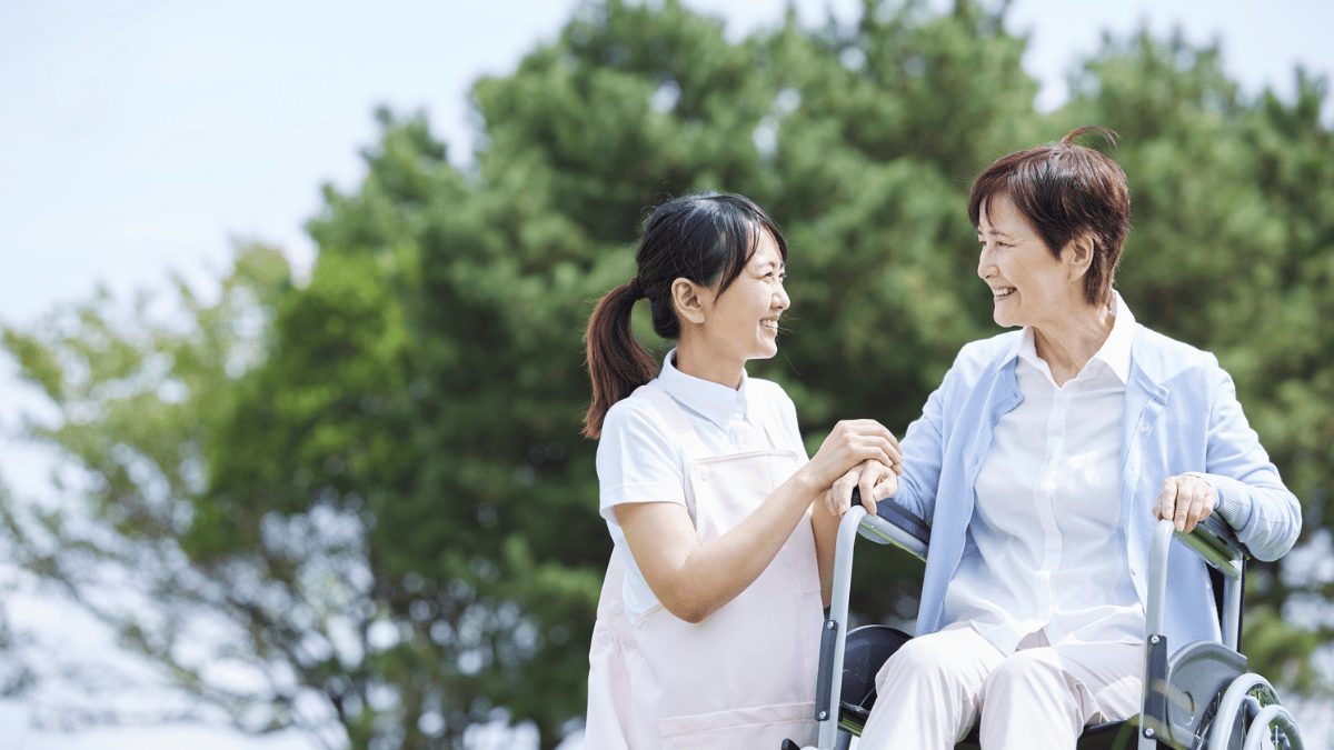 車いすにのる高齢女性と看護師