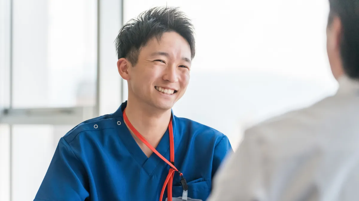 青いスクラブの男性医療者