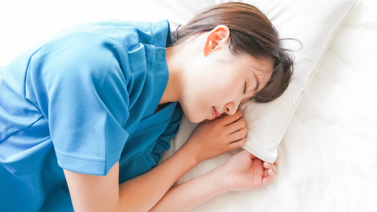 白衣を着た女性が寝ている