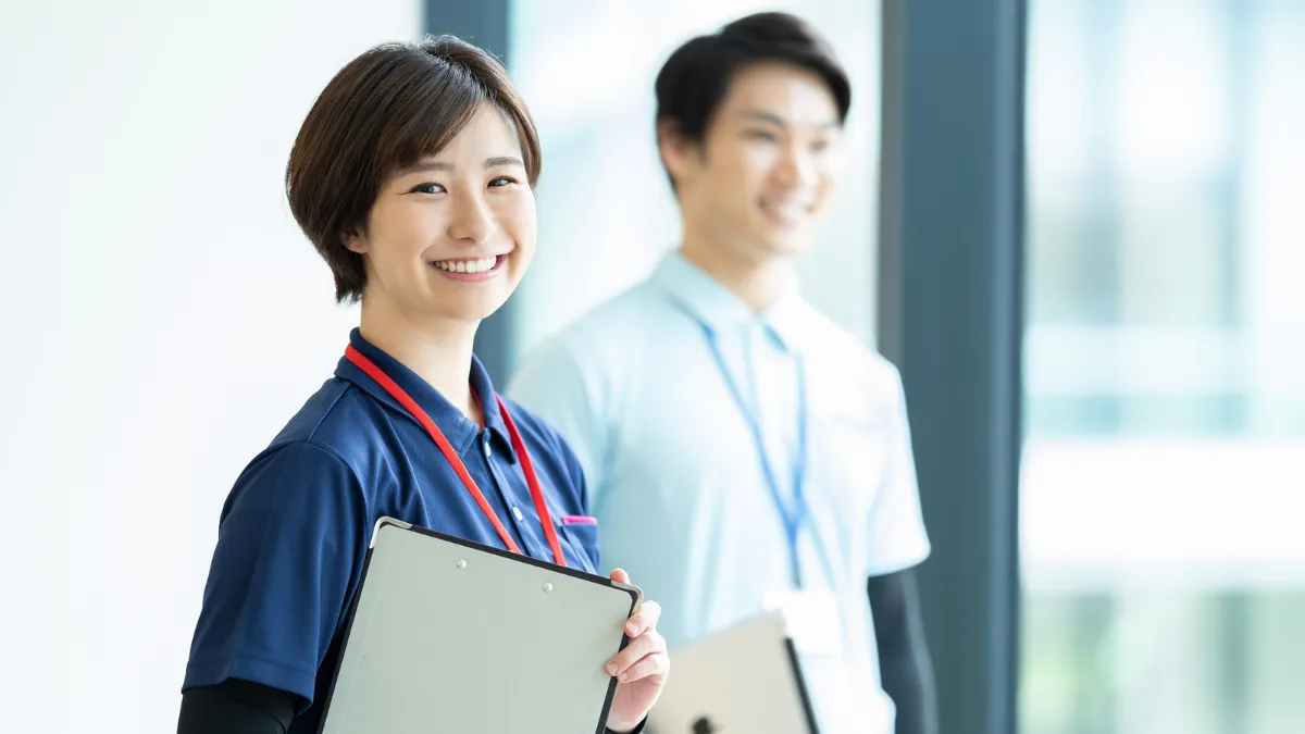 白衣を着た男女が笑顔で立っている