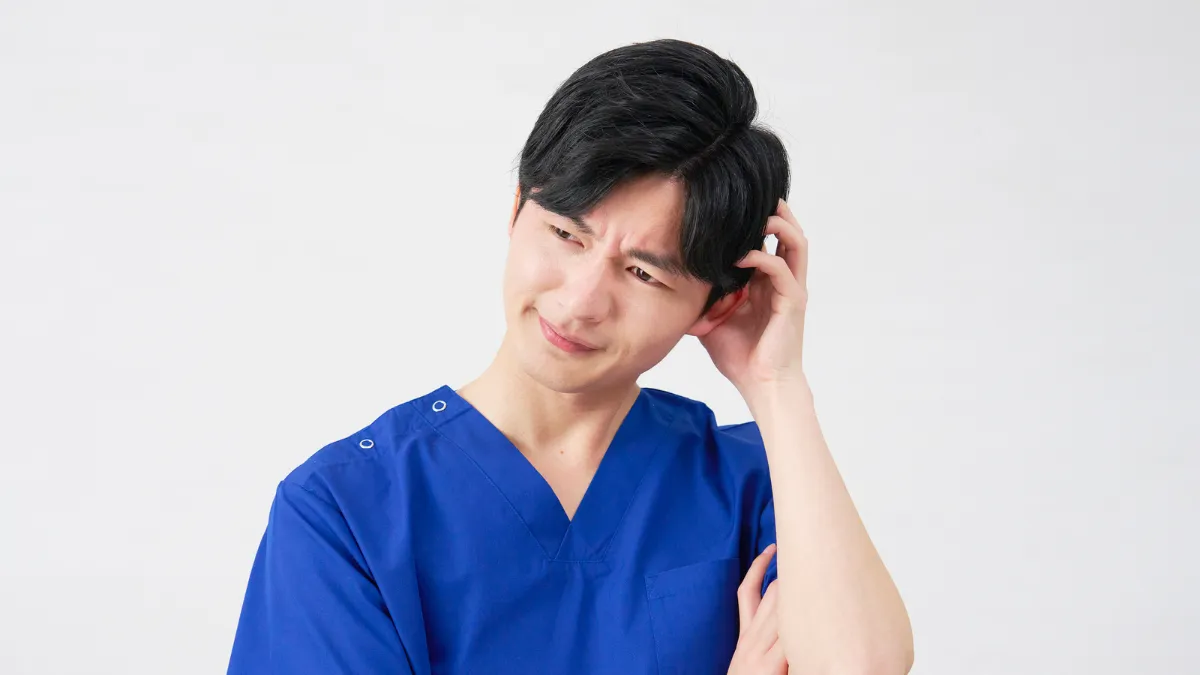 スクラブの男性が頭を抱えてる