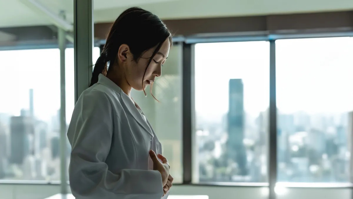 白衣の女性が悩んでる