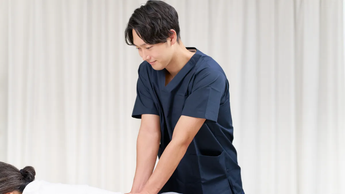 スクラブの男性が施術している