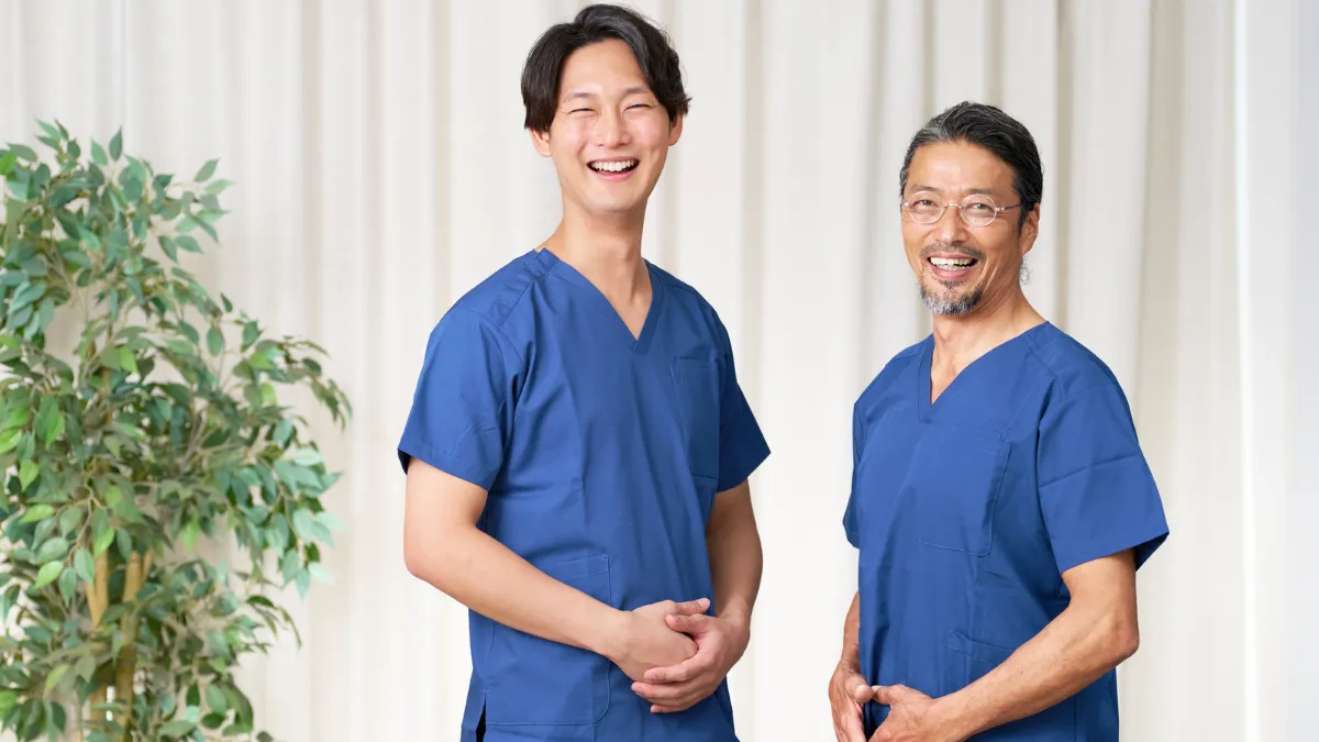 笑顔のベテランと若手のあん摩マッサージ指圧師