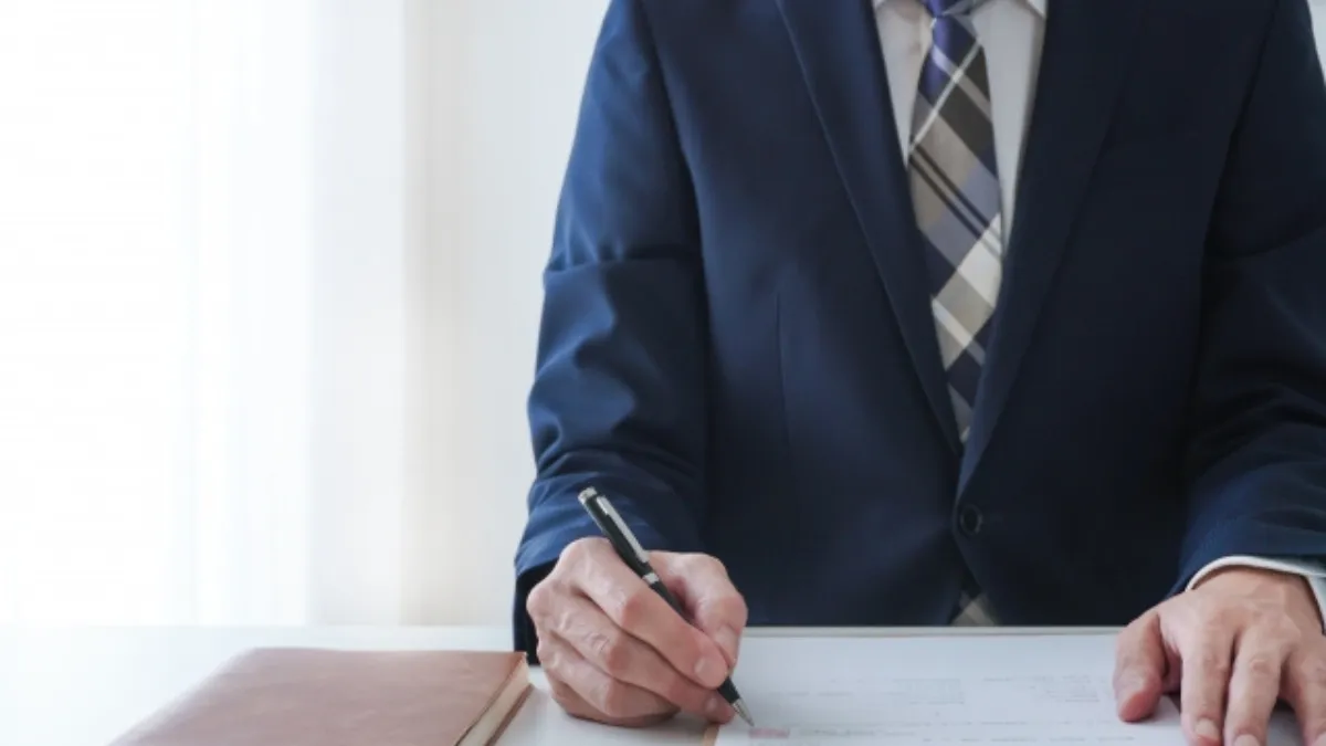 書類に記入する男性の手元