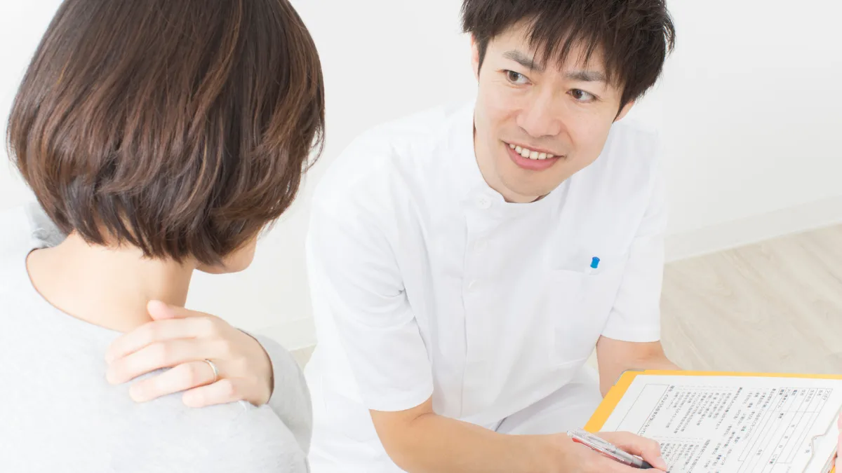 柔道整復師が患者さんに問診表を使って説明している様子