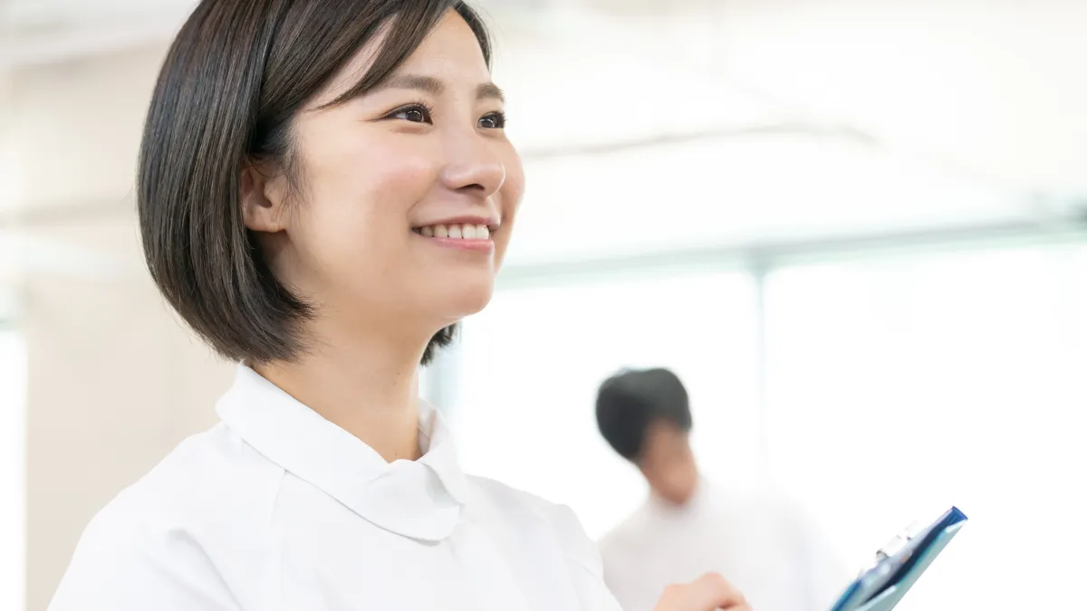 資料を持って学ぶ柔道整復師の笑顔