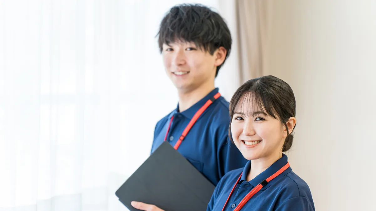 柔道整復師の男女がタブレットを見ながら笑顔で話し合っている様子