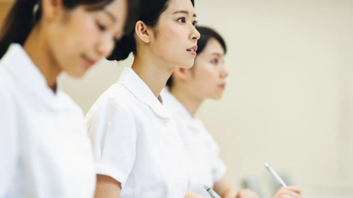 ペンを持ちメモを確認する薬剤師