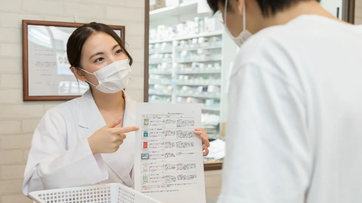 薬剤師が調剤薬局で処方薬について説明している様子