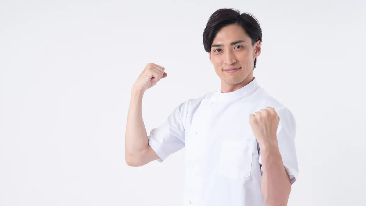 元気よくガッツポーズをする男性鍼灸師