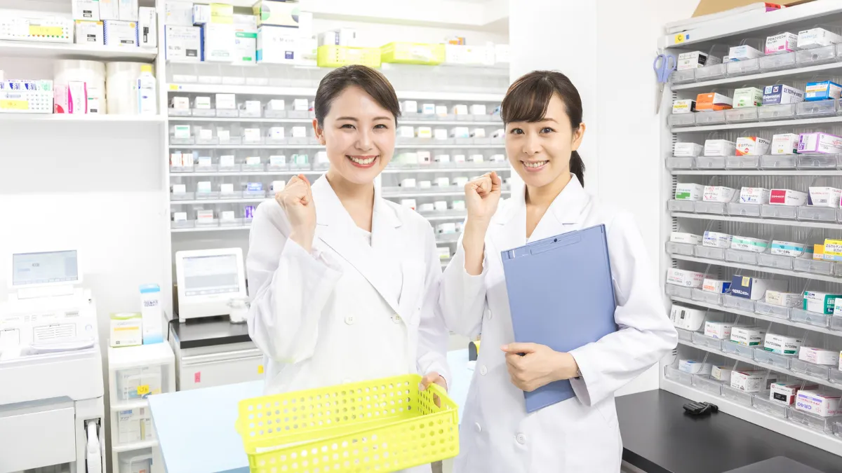 調剤室にて薬剤師2人が笑顔でガッツポーズしている