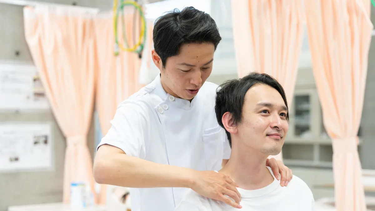 鍼灸師が患者の肩をマッサージしている様子