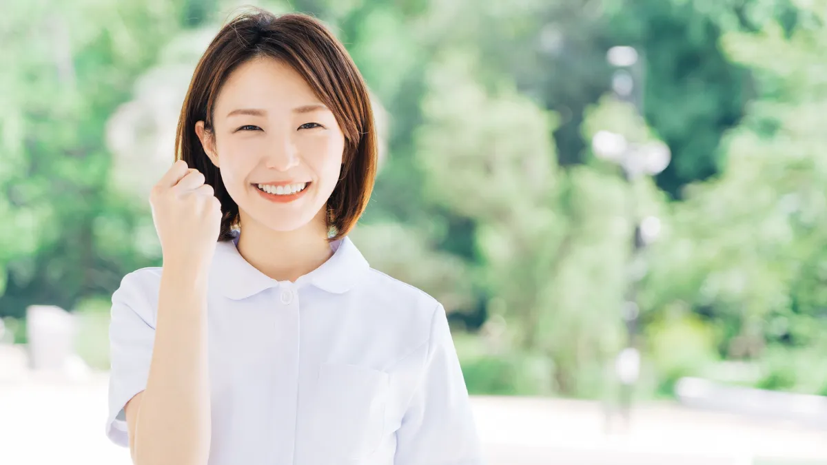 看護師が屋外でガッツポーズをしている様子
