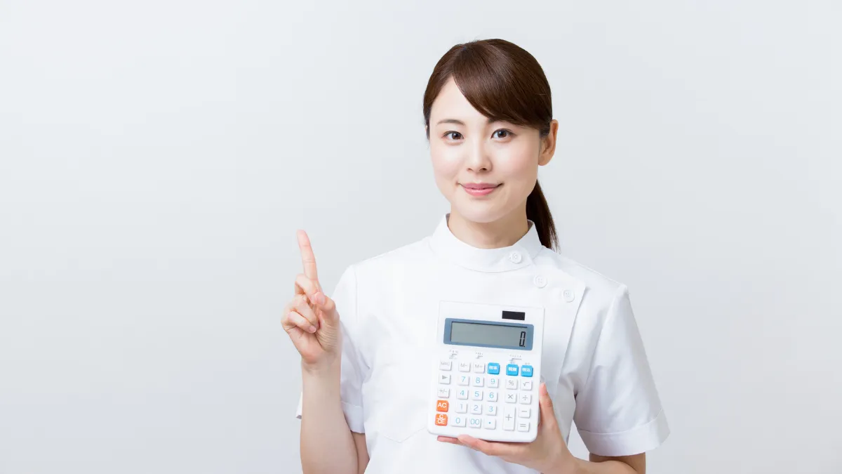 電卓で年収を計算する看護師
