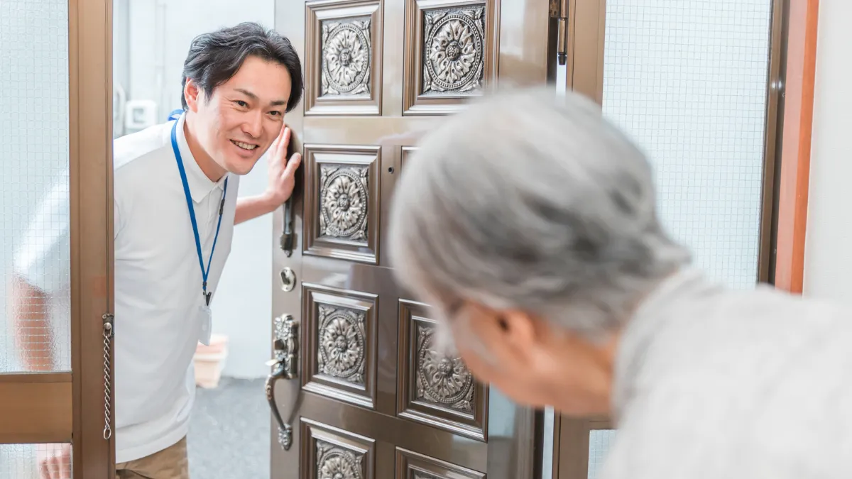 利用者宅を訪問して挨拶する訪問看護師