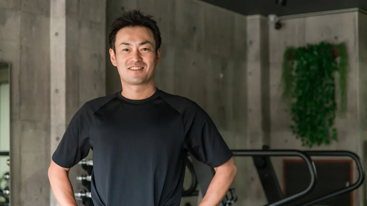 Tシャツ姿でスポーツジムに立つ柔道整復師
