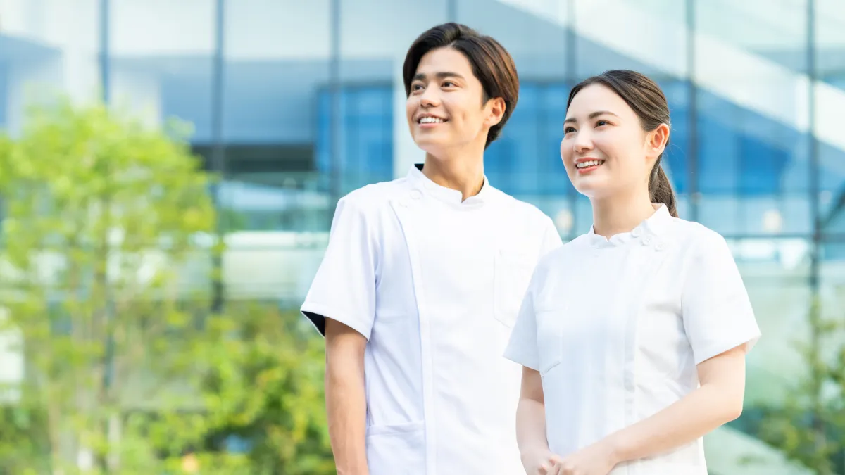 屋外で前向きな表情を見せる柔道整復師の男女
