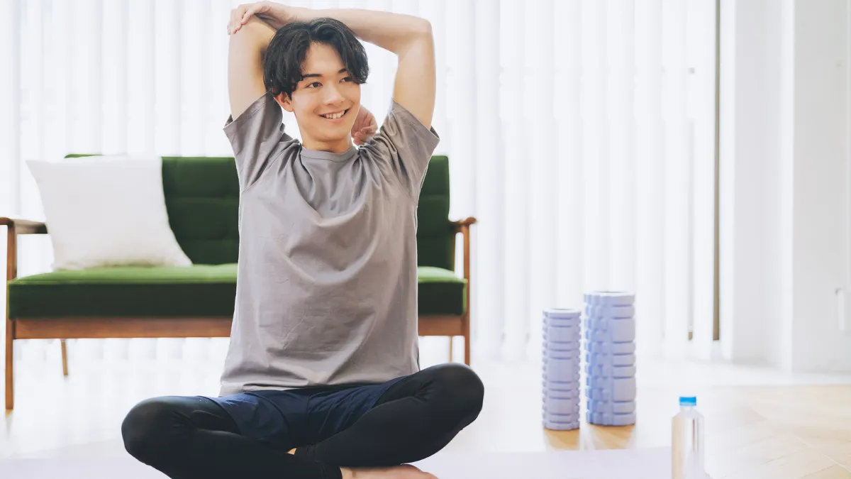自宅でストレッチやトレーニングをする男性