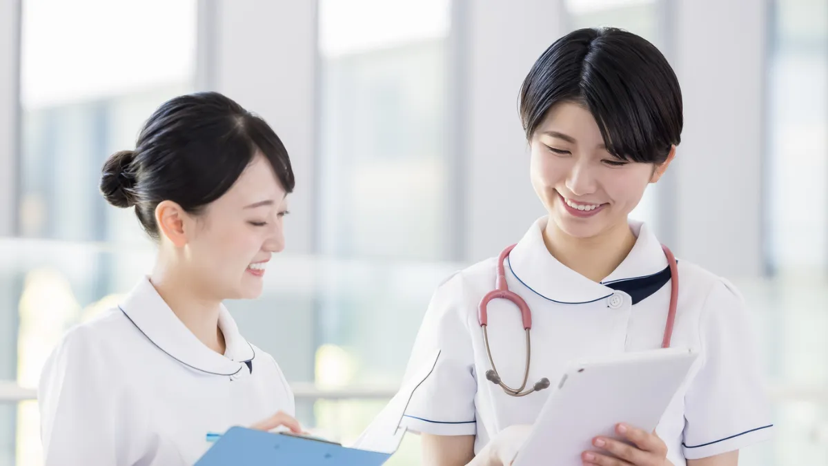 同僚と向かい合って相談する看護師