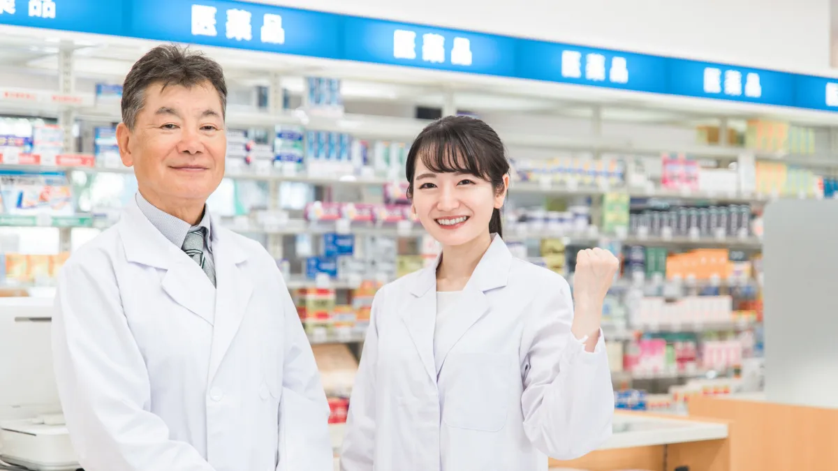 調剤薬局でガッツポーズをする笑顔の薬剤師