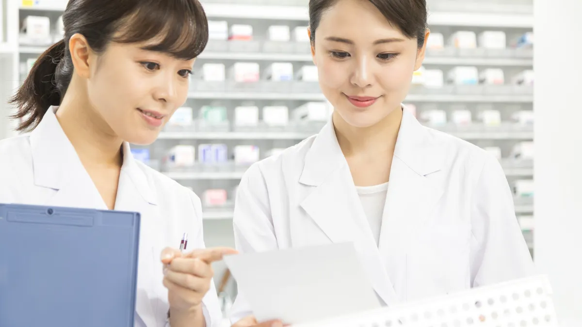 閉店後に監査を行う2人の薬剤師