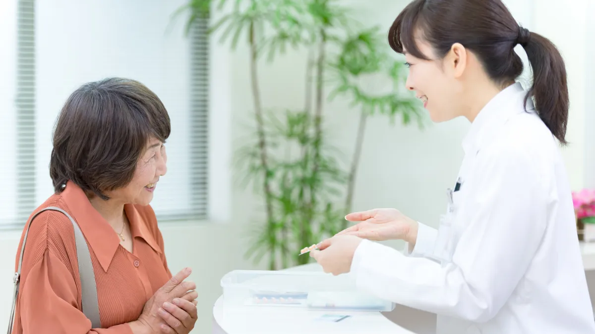 調剤薬局で患者さんに薬を説明する薬剤師