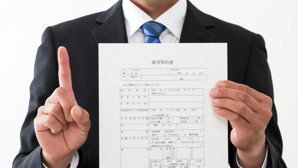 雇用契約書を持つスーツ姿の男性