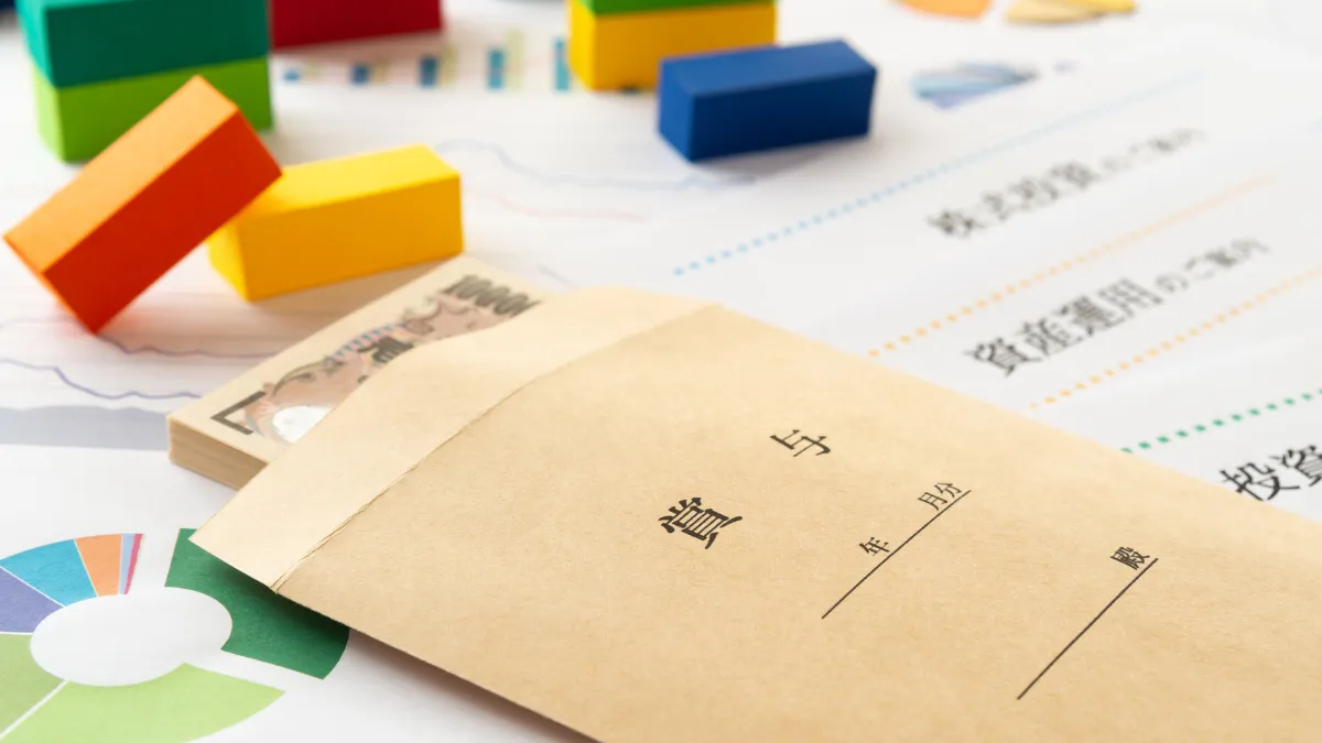 賞与（ボーナス）が入った封筒と現金