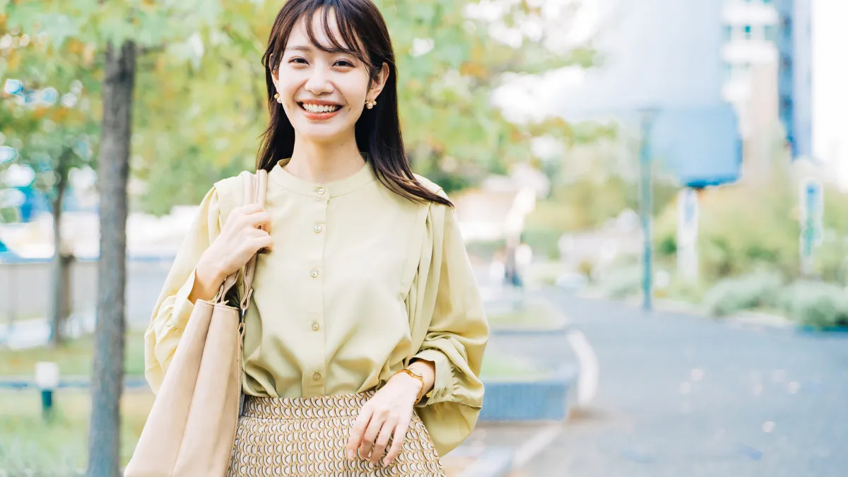 オフィスカジュアルで笑顔の20代女性