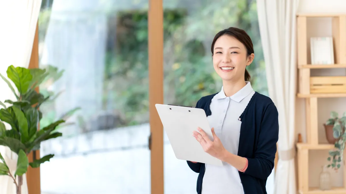 バインダーにメモを取りながら考える薬剤師の女性