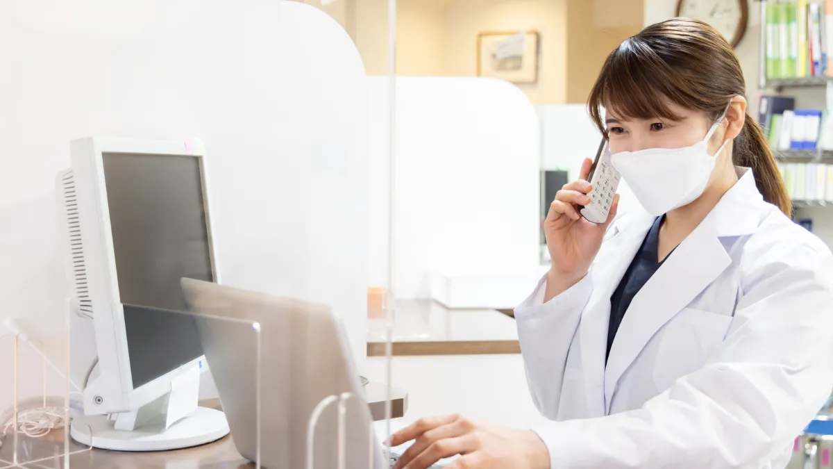 電話とパソコンで面接の日程を調整する薬剤師