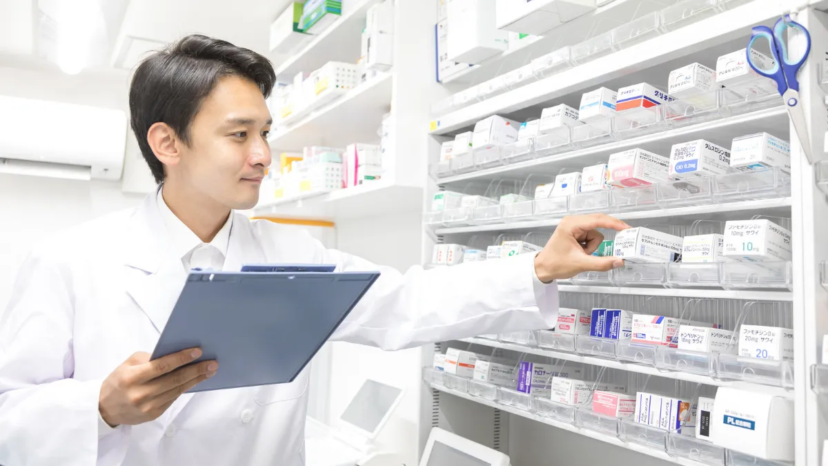 調剤薬局で薬を選ぶ男性薬剤師