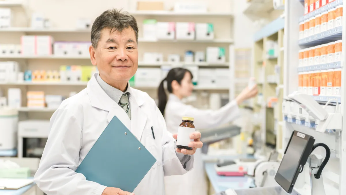 調剤室で相談に応じるベテランの管理薬剤師