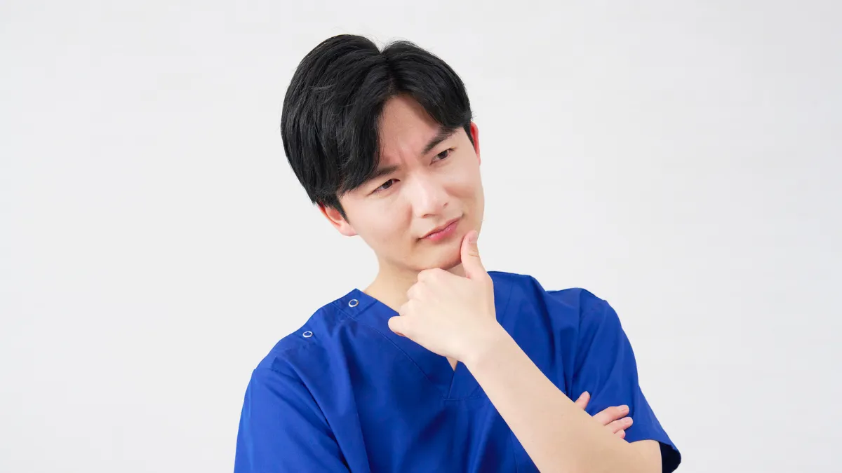 免許取り消しについて考え込む柔道整復師の男性