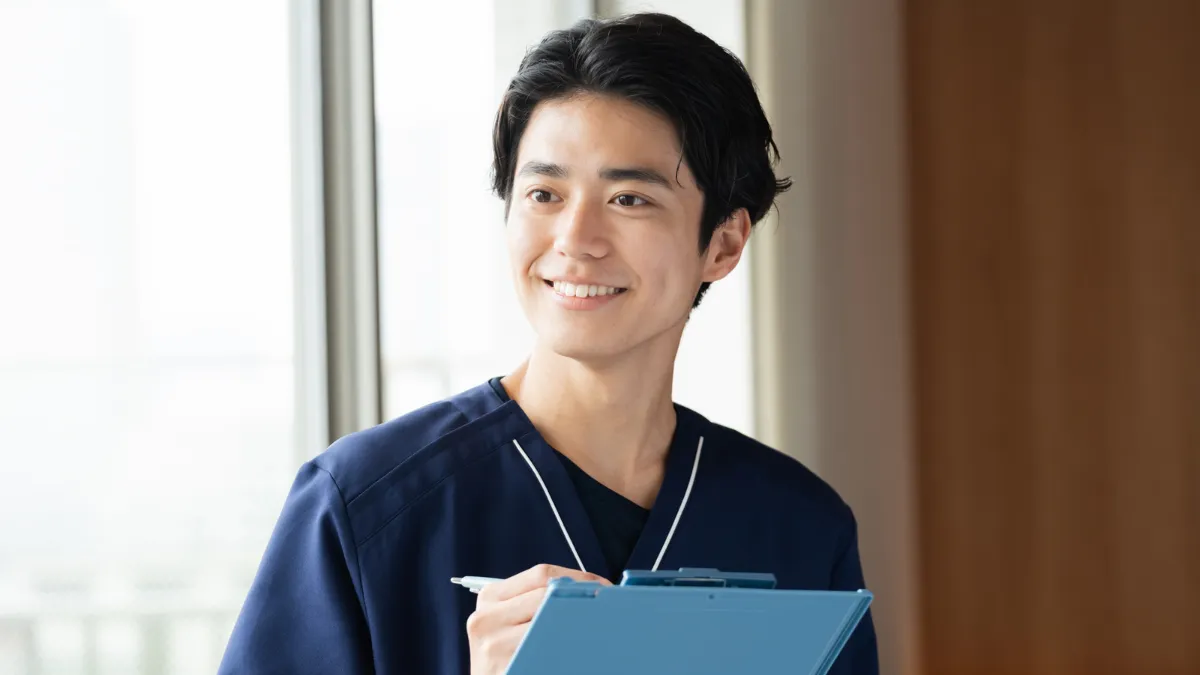 バインダーにメモを取りながら記録を残す柔道整復師