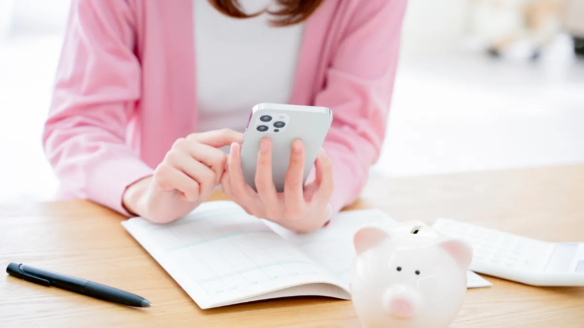 スマートフォンで家計簿をつける手元