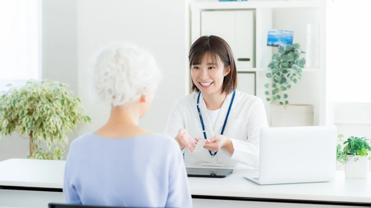 在宅訪問で患者さんに薬を説明する薬剤師