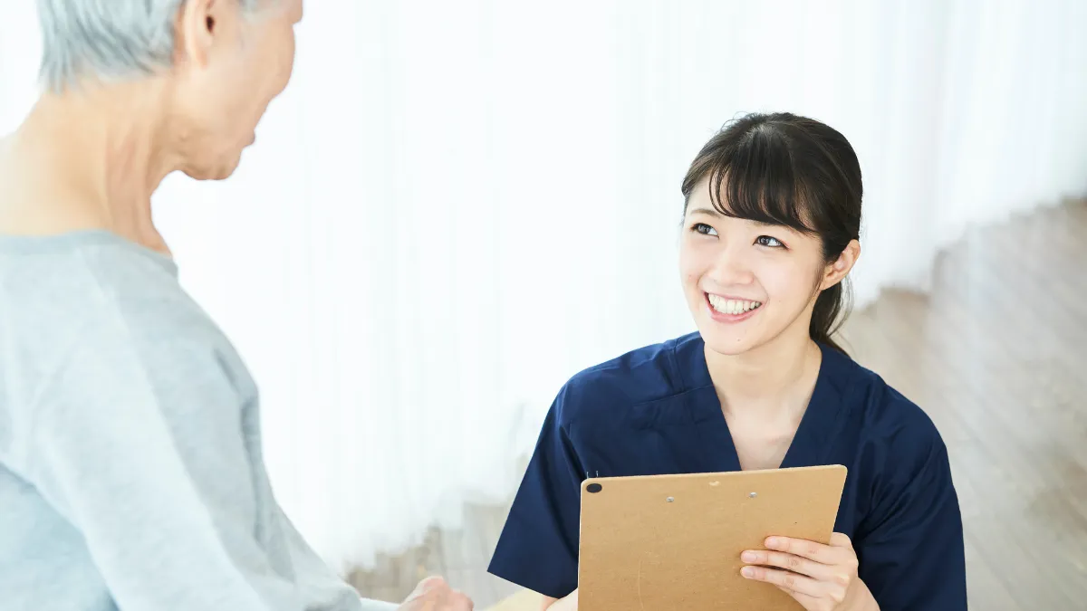 問診表を見ながら患者さんに説明する女性の柔道整復師