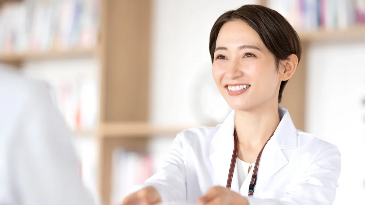 調剤薬局で患者さんに薬を渡す女性薬剤師