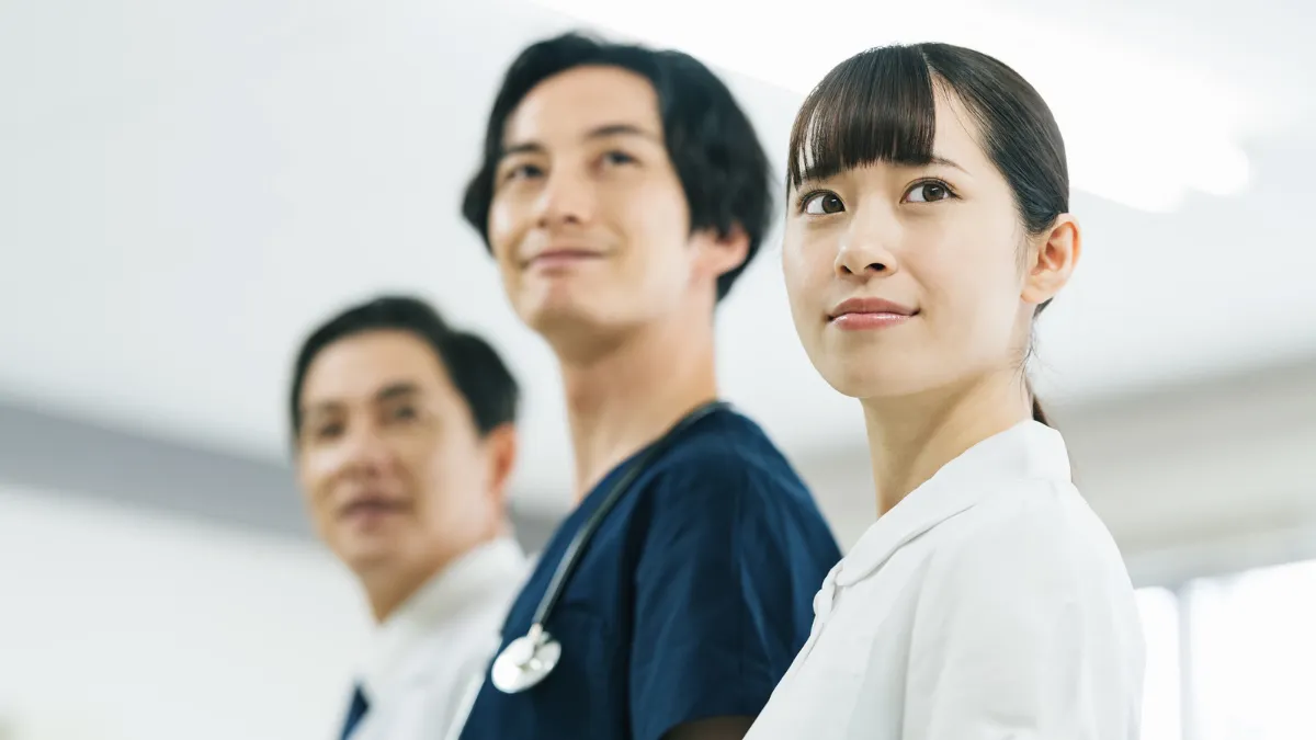 医師や多職種とともに前を見つめる看護師