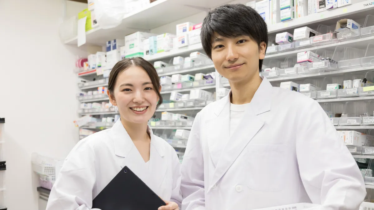 調剤室で笑顔を見せる男性と女性の薬剤師