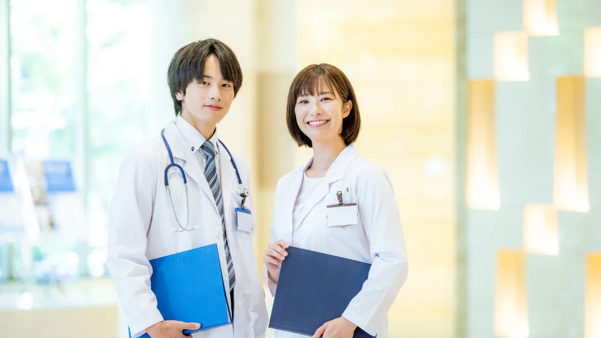 医師と並んで正面を向く男女の薬剤師