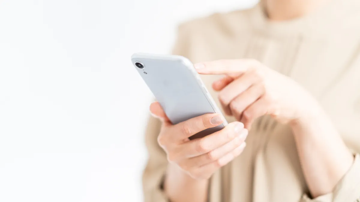 スマートフォンを操作する女性の手元