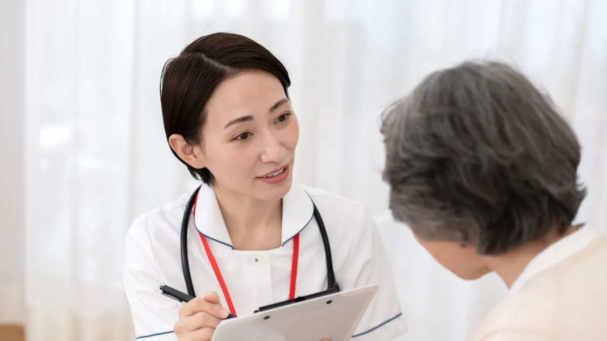 患者さんに近況を聞きながら説明する看護師