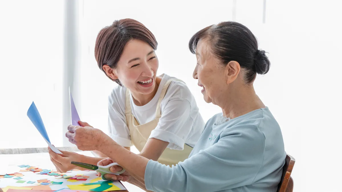 高齢者と一緒に折り紙を楽しむ看護師
